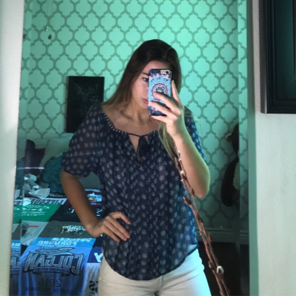 Sheer blue blouse with a tie in the front.
